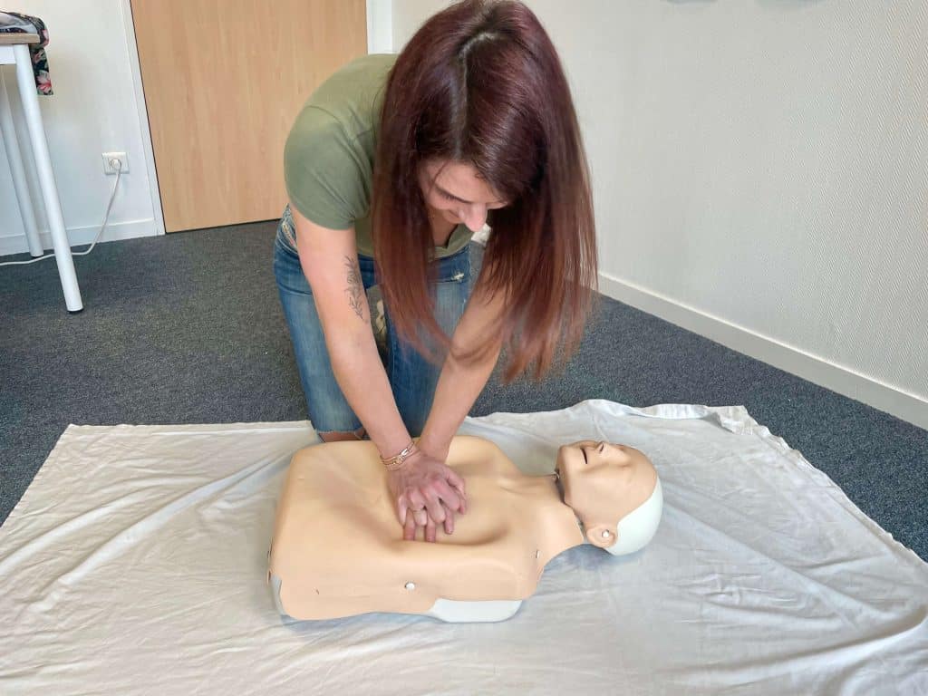 Une professionnelle en pleine formation de massage cardiaque manuel sans DAE pendant une formation SST à Pau