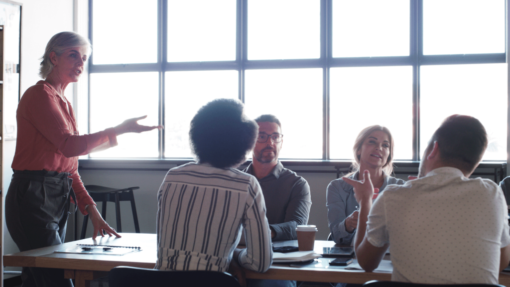 Professionnels en réunion de co-développement, échangeant des idées pour résoudre des problématiques communes dans un cadre collaboratif.